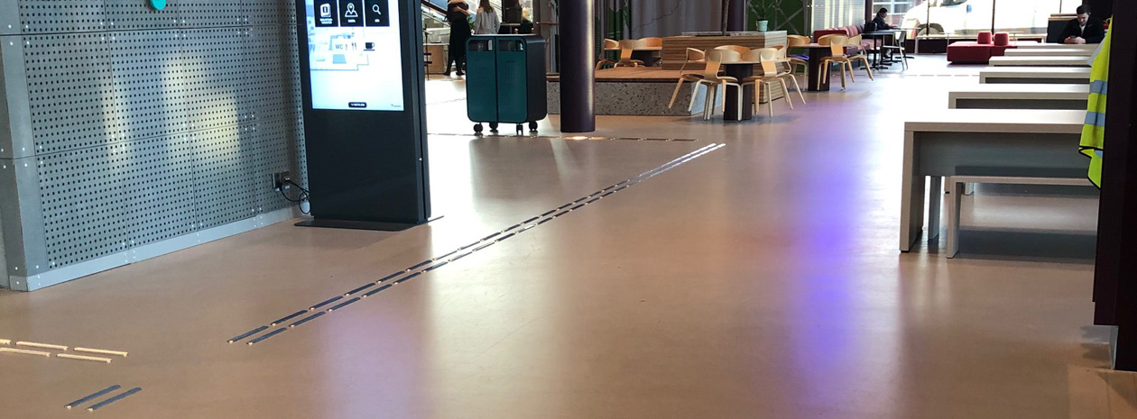 Taktila ledstråk Line av rostfritt stål visar vägen i studenthuset Campus Valla i Linköping.